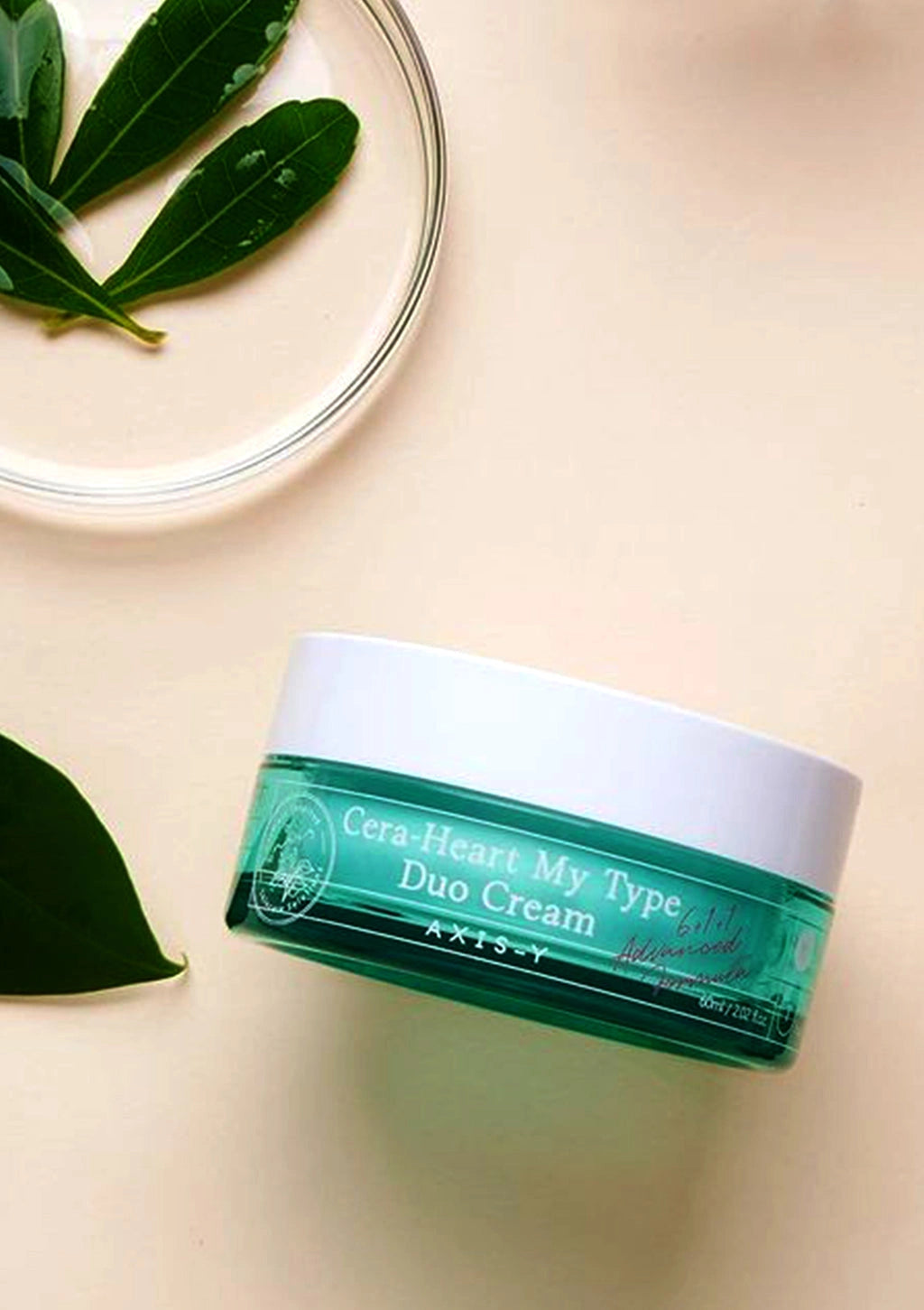Green jar of 'CeraHeal My Type Duo Cream' on a beige background with leaves.